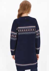 Tengerészkék kötött pulóver hosszú ujjakkal, a hátán és az ujjakon piros, fehér és kék mintás vállrészével. Laza szabás.