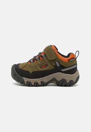 Wanderschuhe für Kinder, grün-schwarzes Obermaterial, aus Wildleder und Textil, mit Klettverschluss, grauen Schnürsenkeln, robustem Profilsohle und orangefarbenen Akzenten.