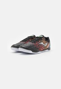 Zapatillas deportivas negras con parte superior sintética texturizada que presenta un patrón escamoso en rojo y naranja, suela de goma blanca y cordones negros.