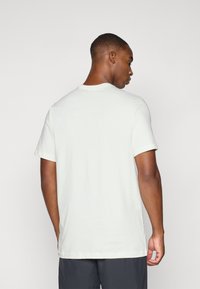 Lysegrå t-shirt lavet af blødt stof, med korte ærmer og rund halsudskæring, med en glat tekstur og uden synlige mønstre.