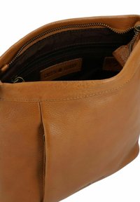 Borsa a tracolla in pelle color tan con texture liscia, dotata di chiusura a zip e foderata in tessuto scuro. L'etichetta interna riporta la scritta "GREEN BURRY."