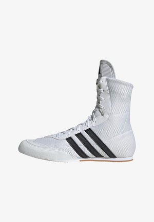 White athletic shoe with high ankle, mesh upper, and three black stripes. Features reinforced toe cap and textured sole.