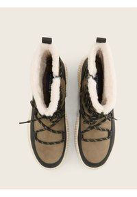 Braune und schwarze High-Top-Schuhe mit einem plüschigen weißen Futterkragen, strukturiertem Material, schwarzen Schnürsenkeln und Gummisohlen mit Rillen.