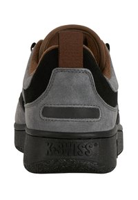 Grå mockaskor med svarta accenter, vadderad krage och brun nätfoder. Utrustad med strukturerad svart gummisula och varumärke på hälen.