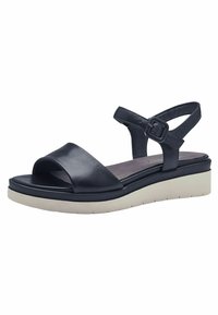 Sandale en cuir noir avec un bout ouvert et une sangle de cheville réglable, dotée d'une semelle compensée blanche contrastante et d'une texture lisse.