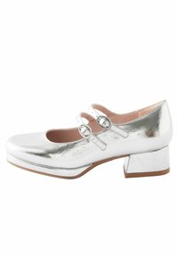 Silberne Lackleder-Mary Jane-Schuh mit runder Zehenpartie, zwei Schnallenriemen und Blockabsatz. Glatte Textur und glänzende Oberfläche.