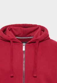 Rote Kapuzenjacke mit durchgehendem Reißverschluss, verstellbaren Kordeln, gerippten Bündchen und einem glatten, strukturierten Stoff. Hat einen silbernen Reißverschluss und eine gefütterte Kapuze.