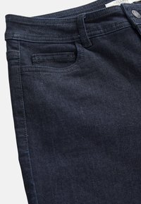 Mörkblå denimjeans med en slät yta, med en standard midjeband, liten ficka framtill och minimala sömnadsdetaljer.