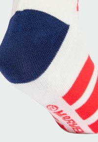 Biała skarpetka z czerwonymi paskami i granatowym obcasem. Posiada prążkowaną teksturę i wzmocniony palec z logo "Make Your Mark" w kolorze czerwonym.