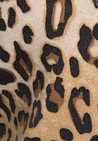 Tela de estampado de leopardo con un fondo texturizado en tono marrón claro y manchas en marrón oscuro y negro, creando un patrón atrevido inspirado en el animal.