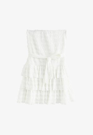 Abito bianco a strati realizzato in tessuto texturizzato, con un bodice arricciato e una cintura legata in vita. I strati hanno bordi arricciati.