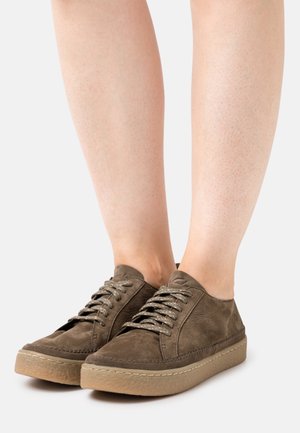 Baskets en cuir marron à profil bas, bout rond, dessus texturé et semelle extérieure en caoutchouc clair ; elles présentent une fermeture à lacets et des détails de coutures.