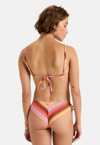 Gestreiftes Bikini-Set mit mehrfarbigen Mustern in Pink, Orange und Braun. Verfügt über dünne, verstellbare Träger und einen Bindeschnüroffstellung am Rücken.