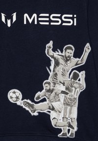 Σκούφος ναυτικού με γραφικό σχέδιο τριών ποδοσφαιριστών σε δράση, με το λογότυπο "MESSi" να προβάλλεται prominent.