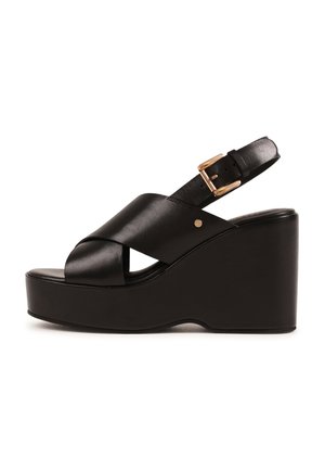 Fekete bőr ék talpú szandál keresztezett elülső pántokkal, állítható arany csattal az boka pánton és vastag platform talppal.