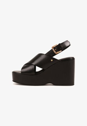 Fekete bőr ék talpú szandál keresztezett elülső pántokkal, állítható arany csattal az boka pánton és vastag platform talppal.