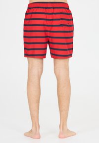 Shorts de bain rouges avec des rayures horizontales bleu marine, taille élastique et une poche arrière. Matériau léger offrant un ajustement décontracté.