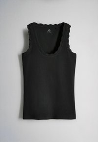 Débardeur noir sans manches à côtes avec bords festonnés sur le col et les emmanchures, posé à plat sur un fond gris clair.