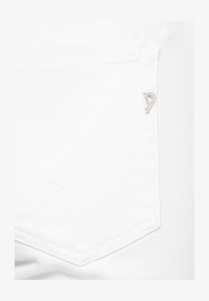 Primo piano della tasca in denim bianco con una piccola targhetta metallica argentata nell'angolo in alto a destra e un sottile dettaglio di cuciture curve.