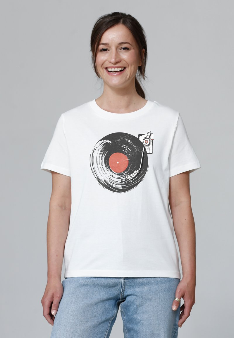 T-shirt en coton blanc avec un graphique de disque vinyle noir au centre rouge et des détails de stylo, à manches courtes et à coupe standard.