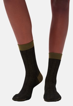 Zwarte sokken met een gestructureerd herringbone-patroon, olijfgroene boorden en een verstevigde hiel. Gebreid materiaal met een zachte afwerking.