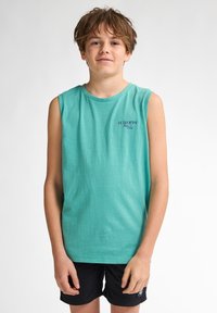 Turkisærmeløs skjorte med rund hals og en mørk tekstlogo; parret med sorte shorts med en lille logoaccent.