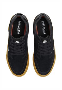 Black suede sneakers with a rubber gum sole, featuring black laces, red interior accents, and "HELIUM" logo on the insole.