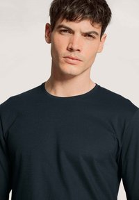 Donkerblauw long-sleeve T-shirt met ronde hals, gemaakt van een katoenmix. Glad textuur met minimale naden, zonder zichtbare logo's of patronen.