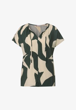 Camiseta de manga corta en color crema con un patrón abstracto de hojas verdes. Presenta un escote en V con cordones y un corte relajado. Textura de tela suave.