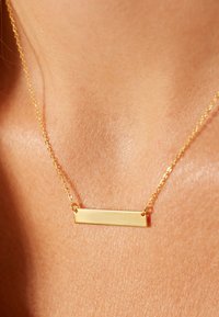 Gouden ketting met een vlakke rechthoekige hanger. De ketting heeft een klassiek ontwerp met een gladde textuur.