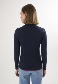 Maglione a maniche lunghe blu navy con scollatura rotonda e polsini a coste, caratterizzato da un bordo rosso a contrasto all'orlo. Materiale in misto cotone.