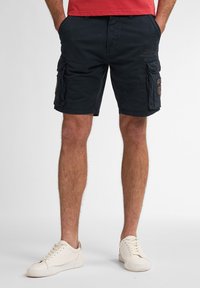 Marine cargoshorts med flere sidelommer, en afslappet pasform og et robust bomuldsblandingsstof. Parret med hvide sneakers.