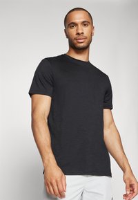 Schwarzes Kurzarm-T-Shirt aus leichtem Material mit Rundhalsausschnitt, das einen lässigen Schnitt und eine dezente Textur aufweist.
