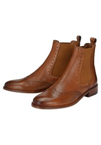 Bottines en cuir marron présentant des panneaux latéraux élastiques, des détails brogues, une texture lisse et un talon bas empilé.