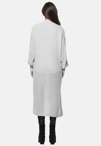 Lång, ljusgrå stickad cardigan med ett texturerat mönster, vida ballongärm och en lös passform som sträcker sig under knäet.