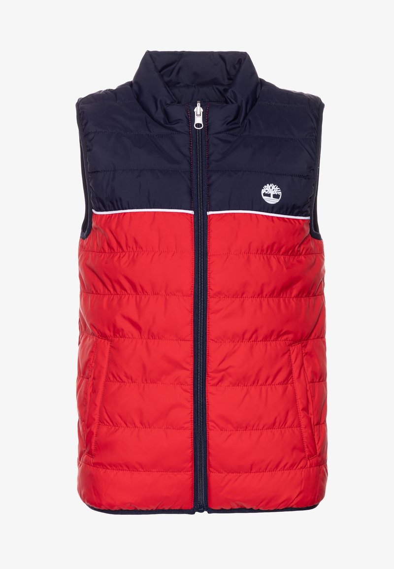 Polstrovaná bezrukávová vesta s námořnickou modrou horní částí a červenou dolní částí, s předním zipem a bílým střihem. Logo na hrudi.