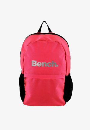 Roza tkaninska nahrbtnik s sprednjim žeparjem z zadrgo, črnimi detajli in srebrnim logotipom "Bench." poudarjeno prikazanim spredaj.