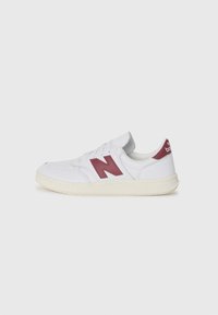 Hvite joggesko med et maroon "N"-logo, teksturert læroverdel, perforeringer på tåen, gummisåle og polstret krage for komfort.
