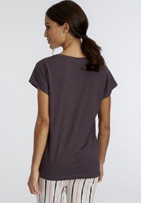 Paarse T-shirt met korte mouwen, een relaxte pasvorm en een ronde halslijn, gecombineerd met gestreepte pyjamabroek in pastelkleuren.