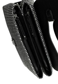 Borsa intrecciata in bianco e nero con due scomparti con zip, caratterizzata da dettagli in ecopelle nera testurizzata e accessori in metallo argentato.