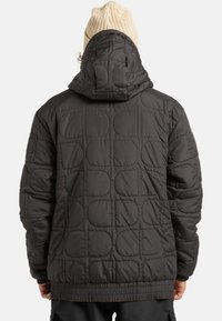 Czarna pikowana kurtka z kapturem i elastycznymi mankietami. Posiada teksturowane wykończenie i prążkowany dół.