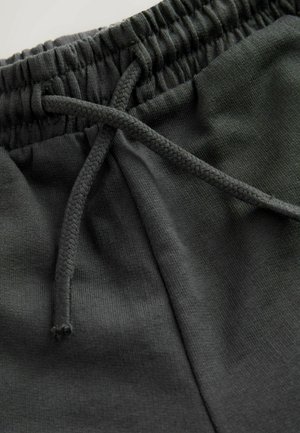 Tummanharmaat puuvillaiset collegehousut, joissa on joustava vyötärönauha ja punottu kiristysnauha sekä sileä pinta.