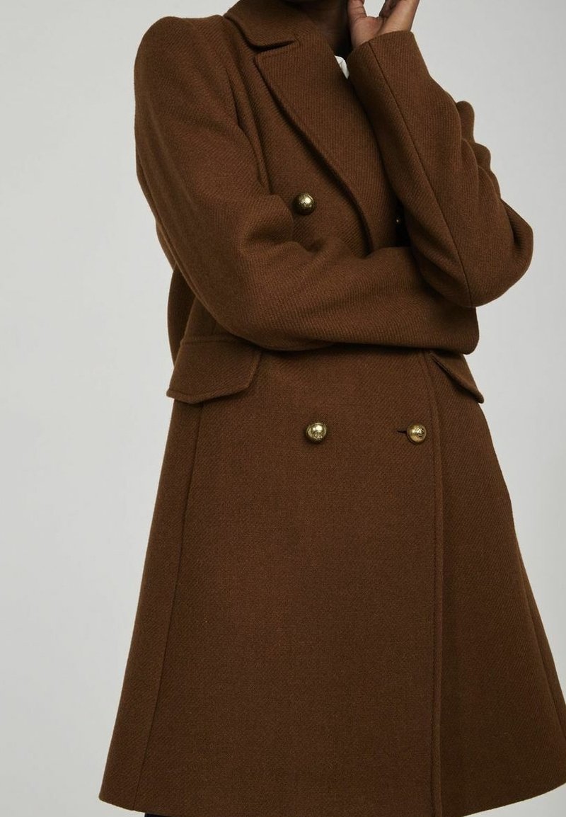 Brown wool blend double-breasted coat with a tailored fit, featuring large gold buttons and side pockets, displayed against a neutral background.