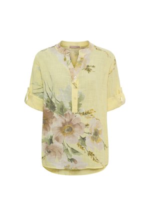 Lysegul bluse med opsmøgede ærmer, blomstertryk i afdæmpede nuancer og kort knaplukning ved halsudskæringen.