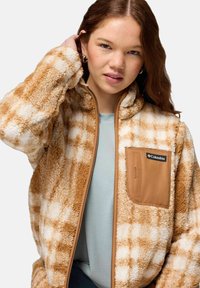 Brown and white plaid fleece jacket with a zip front, elastic cuffs, and a chest pocket featuring a brown accent.