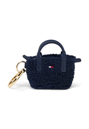 Porte-clés mini-sac à main en tissu texturé bleu marine avec poignées foncées et petit détail de drapeau rouge, blanc et bleu à l'avant.