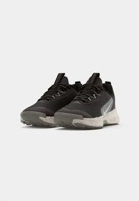 Zwarte hardloopschoenen met een gestructureerde bovenkant, reflecterend Swoosh-logo en een gespikkelde zool. Voorzien van een gepolsterde kraag en veters voor een stevige pasvorm.