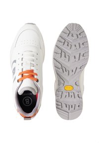 Baskets blanches avec lacets orange vues de dessus et de dessous, présentant une semelle crantée grise avec logo Vibram jaune.