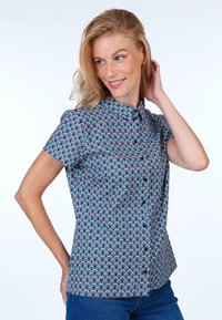 Short-sleeve button-up shirt featuring a blue background with a repeating pink and teal wave pattern, made of lightweight fabric with a collar.