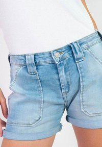 Lichtblauwe denim shorts met een opgerolde zoom, voorzien van een knoopsluiting aan de voorkant, twee zijzakken en zichtbare stikseldetails.